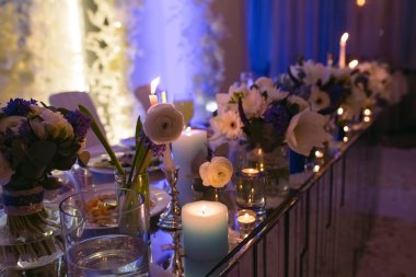 Akşamları bir masada mumlar ve çiçekler