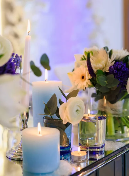 Akşamları bir masada mumlar ve çiçekler.