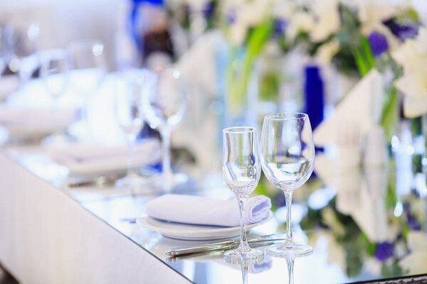 Wedding table setting in the restaurant on the white and blue background.