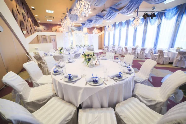 Bruiloft tabel setting in het restaurant op de witte en blauwe achtergrond. — Stockfoto