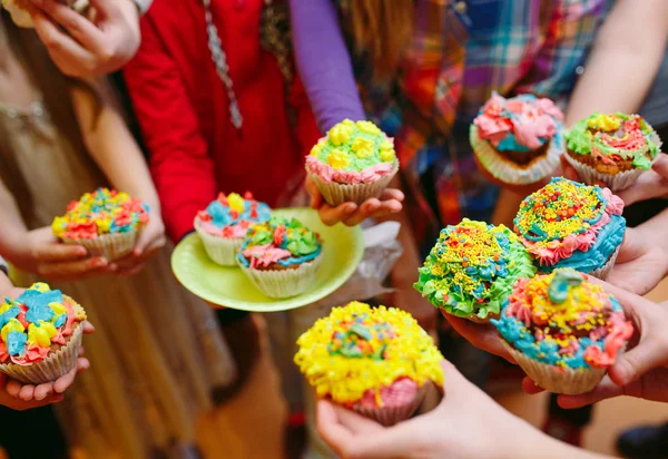 Festa de crianças. Crianças segurando cupcakes nos óculos — Fotografia de Stock