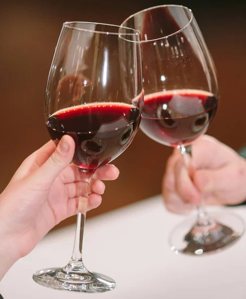 Hombre y mujer bebiendo vino tinto. En la imagen, las manos de cerca con gafas. —  Fotos de Stock