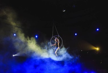 Hava acrobat içinde belgili tanımlık çalmak. Genç bir kız akrobatik öğeleri hava ringde gerçekleştirir..