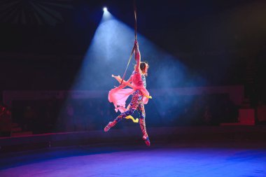 Hava acrobat içinde belgili tanımlık çalmak. Genç bir kız akrobatik öğeleri hava ringde gerçekleştirir..
