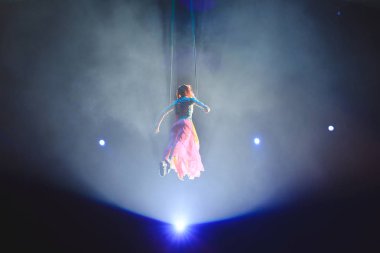 Hava acrobat içinde belgili tanımlık çalmak. Genç bir kız akrobatik öğeleri hava ringde gerçekleştirir..