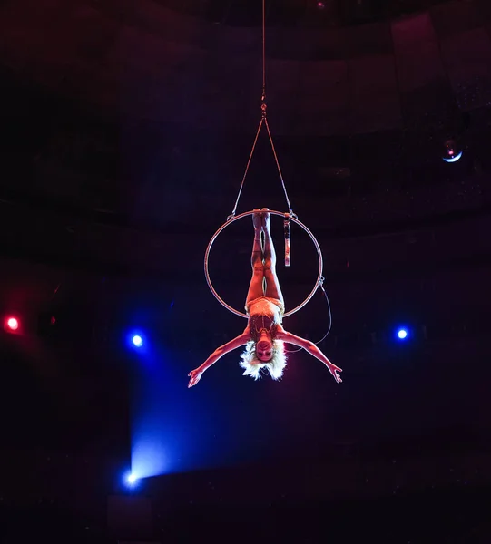 Luchtfoto acrobat in de ring. Een jong meisje voert de acrobatische elementen in de ring van lucht — Stockfoto