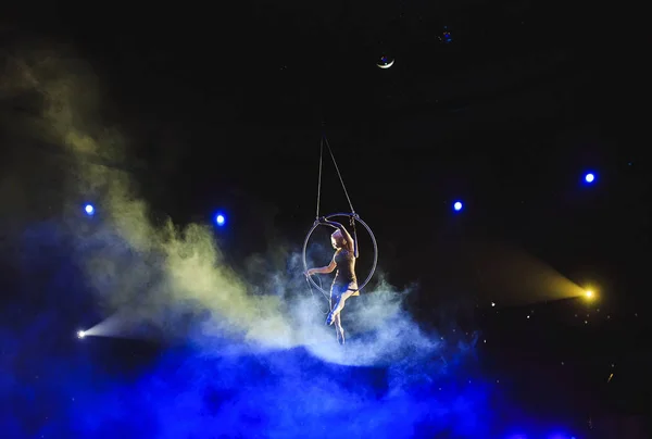 Acróbata aérea en el ring. Una chica joven realiza los elementos acrobáticos en el anillo de aire . — Foto de Stock