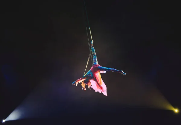 Letecký akrobat v ringu. Mladá dívka provádí akrobatické prvky vzduchu. — Stock fotografie