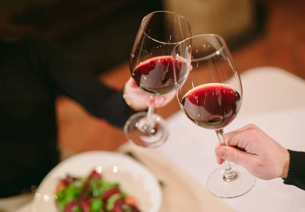 Hombre y mujer bebiendo vino tinto. En la imagen, las manos de cerca con gafas —  Fotos de Stock