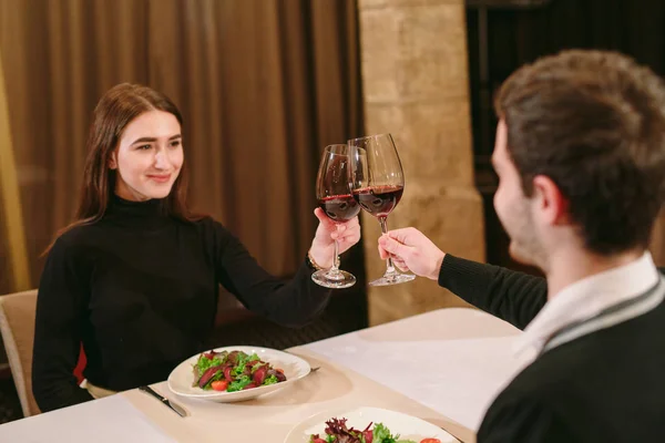 Piękna młoda para z szklanki czerwonego wina w restauracji luksusowe — Zdjęcie stockowe
