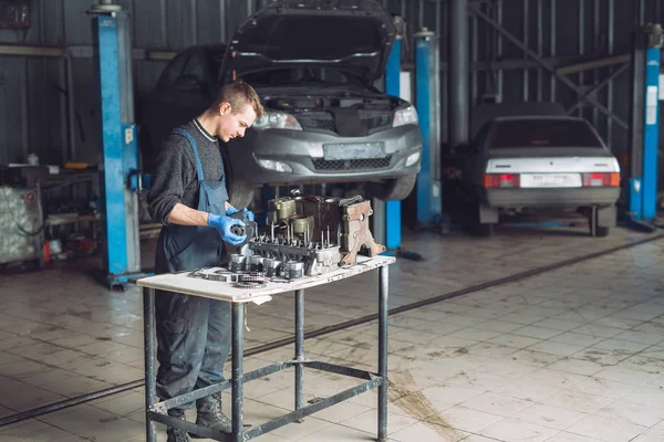 Mestre recolhe um motor reconstruído para o carro — Fotografia de Stock