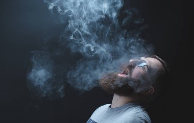 Kavram. Duman kafa adam sardı. Duman ile sakallı, şık bir adam portresi. İkinci el duman.