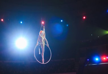 Hava acrobat içinde belgili tanımlık çalmak. Genç bir kız akrobatik öğeleri hava ringde gerçekleştirir.