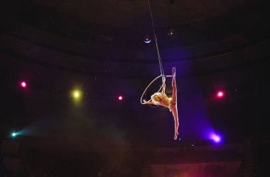 Hava acrobat içinde belgili tanımlık çalmak. Genç bir kız akrobatik öğeleri hava ringde gerçekleştirir..