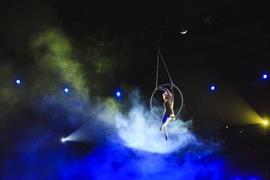 Hava acrobat içinde belgili tanımlık çalmak. Genç bir kız akrobatik öğeleri hava ringde gerçekleştirir..
