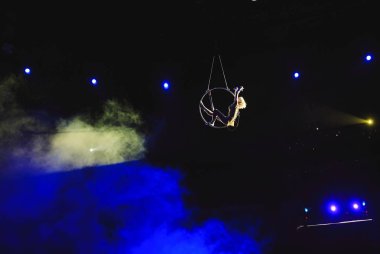 Hava acrobat içinde belgili tanımlık çalmak. Genç bir kız akrobatik öğeleri hava ringde gerçekleştirir..