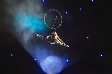 Hava acrobat içinde belgili tanımlık çalmak. Genç bir kız akrobatik öğeleri hava ringde gerçekleştirir.