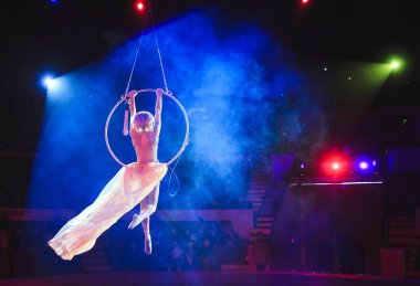 Hava acrobat içinde belgili tanımlık çalmak. Genç bir kız akrobatik öğeleri hava ringde gerçekleştirir.