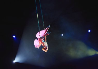 Hava acrobat içinde belgili tanımlık çalmak. Genç bir kız akrobatik öğeleri hava ringde gerçekleştirir..