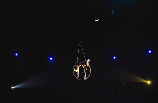 Acróbata aérea en el ring. Una chica joven realiza los elementos acrobáticos en el anillo de aire . — Foto de Stock