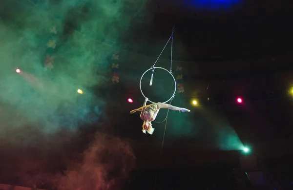 Воздушный акробат на ринге. Молодая девушка исполняет акробатические элементы в воздушном кольце . — стоковое фото