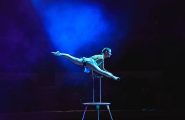 Hava acrobat içinde belgili tanımlık çalmak. Genç bir kız akrobatik öğeleri hava ringde gerçekleştirir.