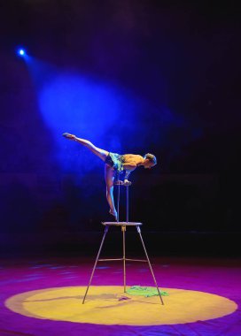Hava acrobat içinde belgili tanımlık çalmak. Genç bir kız akrobatik öğeleri hava ringde gerçekleştirir.