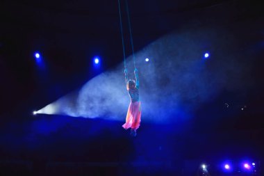 Hava acrobat içinde belgili tanımlık çalmak. Genç bir kız akrobatik öğeleri hava ringde gerçekleştirir..
