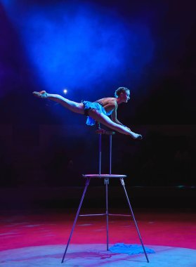 Hava acrobat içinde belgili tanımlık çalmak. Genç bir kız akrobatik öğeleri hava ringde gerçekleştirir.