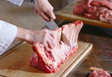 Aşçı bir adam lokantada bıçakla et keser..