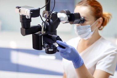 Diş aletleri ile Kadın diş hekimi - mikroskop, ayna ve prob hasta tedavi. Tıp, diş hekimliği ve sağlık konsepti.