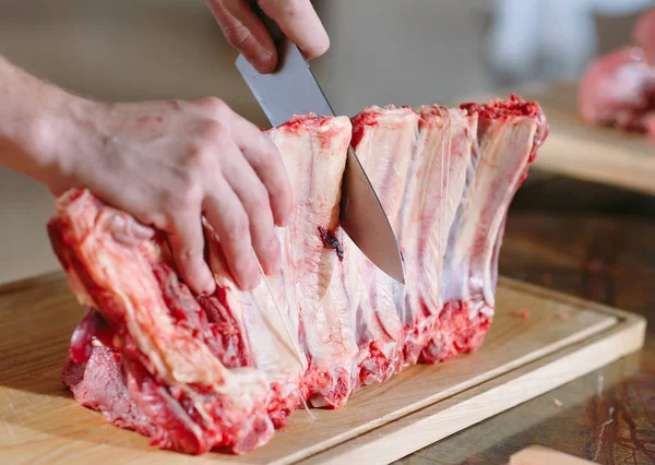 Un cuisinier coupe de la viande avec un couteau dans un restaurant . — Photo