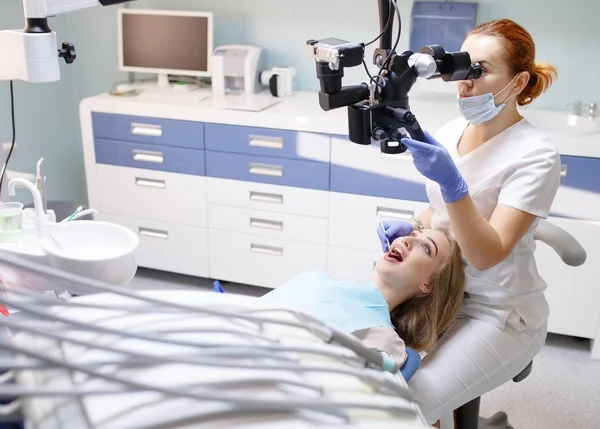 Female dentist with dental tools - microscope, mirror and probe treating patient. Medicine, dentistry and health care concept. — Stock Photo, Image