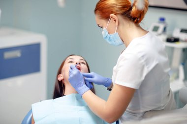 kadın diş hekimi bir klinikte hasta kız dişleri kontrol