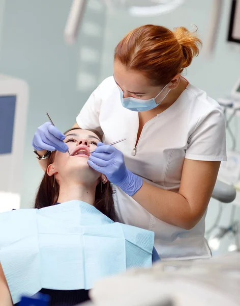 Kobieta dentysta sprawdzanie pacjenta zęby dziewczyna w klinice — Zdjęcie stockowe