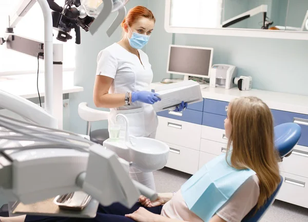 Dentista femenina con paciente niña hablando en el consultorio de la clínica dental — Foto de Stock