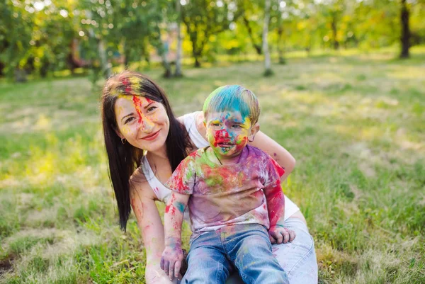Family playing in the park. Family painted in the colors of Holi Festival. — Stock Photo, Image