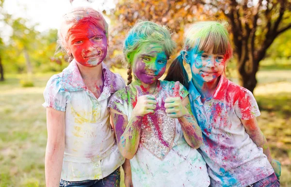 Cute european child girls celebrate Indian holi festival with colorful paint powder on faces and body — Stock Photo, Image