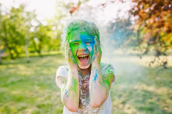 Portrait of a cute girl painted in the colors of Holi festival. — Stock Photo, Image