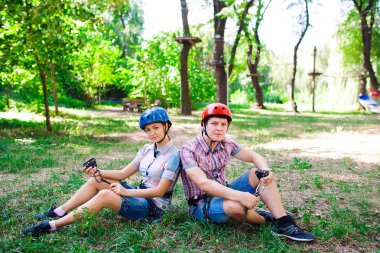 Yüksek telli parka tırmanma macerası - insanlar dağ kaskı ve güvenlik ekipmanları ile rotalarında