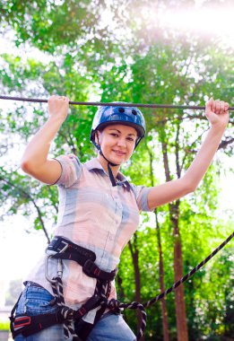 Yüksek telli parka tırmanma macerası - insanlar dağ kaskı ve güvenlik ekipmanları ile rotalarında