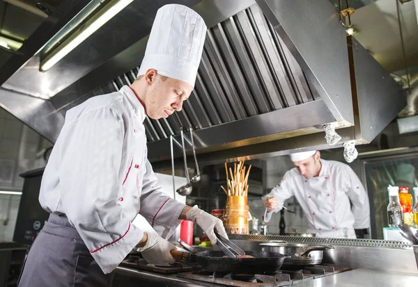 Chef na cozinha do restaurante no fogão com panela, cozinhar — Fotografia de Stock