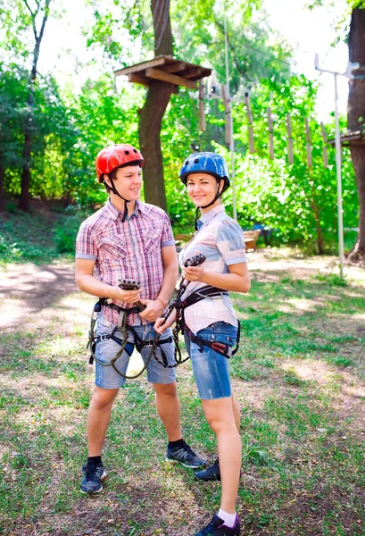 Aventura escalada parque de alambre de alta - personas en curso en casco de montaña y equipo de seguridad — Foto de Stock