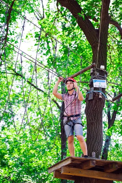 Aventura escalada parque de alambre de alta - personas en curso en casco de montaña y equipo de seguridad — Foto de Stock