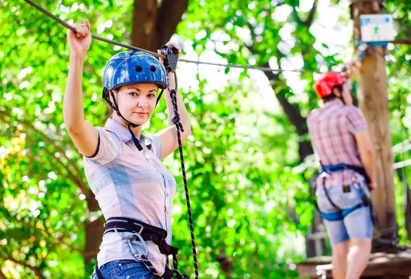 Aventure escalade haut fil parc - les gens sur le cours en casque de montagne et de l'équipement de sécurité — Photo