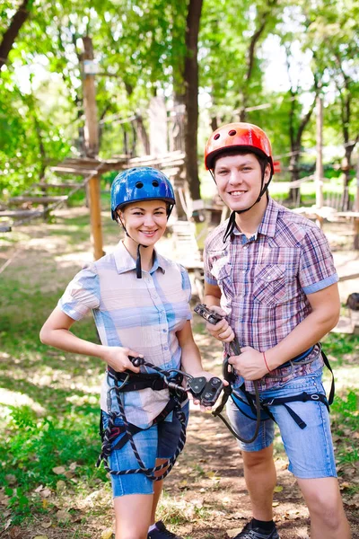 Aventura escalada alto fio parque - pessoas em curso em capacete de montanha e equipamentos de segurança — Fotografia de Stock