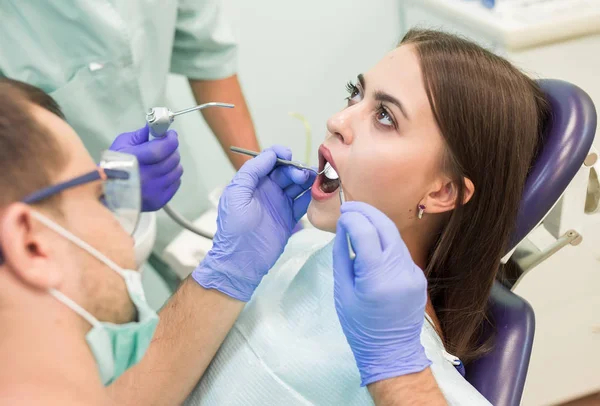 Врач-дантист с ассистентом работает в стоматологической клинике — стоковое фото