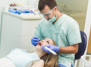 Klinikte diş hekimi ultraviyole ışığı tedavi ediyor.