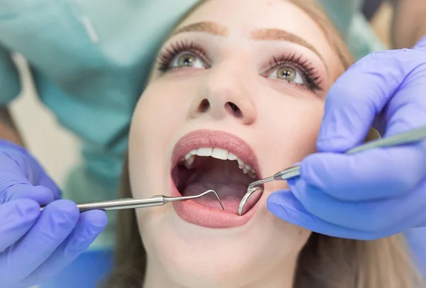 Dentist doing procedure with dental curing UV light in clinic — Stock Photo, Image