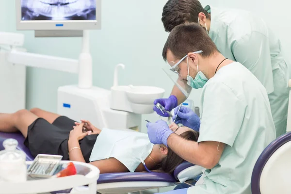 Doctor Dentista con un asistente que trabaja en una clínica dental — Foto de Stock